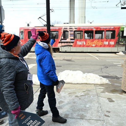 visit buffalo volunteers wave on a visit buffalo-themed metro
